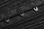 Close-up of metal busk pins on black brocade underbust corset