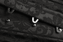 Close-up of metal busk loops on black brocade underbust corset