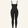 Black open-bust legging bodysuit with adjustable straps on a cream background