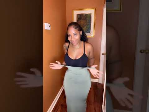 Model wearing black tummy control bodysuit in a lifestyle setting