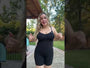 Model wearing black tummy control shapewear bodysuit with adjustable straps and shorts length